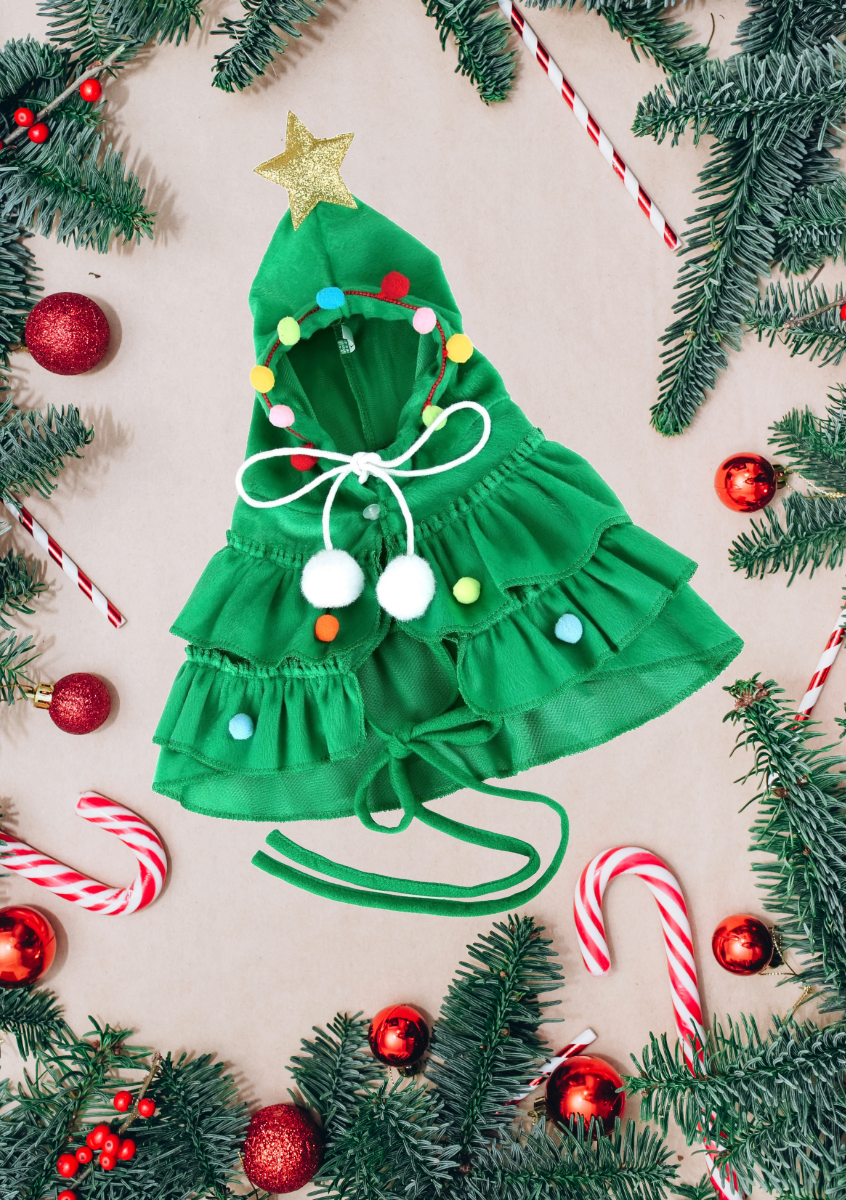 Green Christmas Tree Pet Costume flat lay with candy canes, red ornaments, and pine branches holiday styling